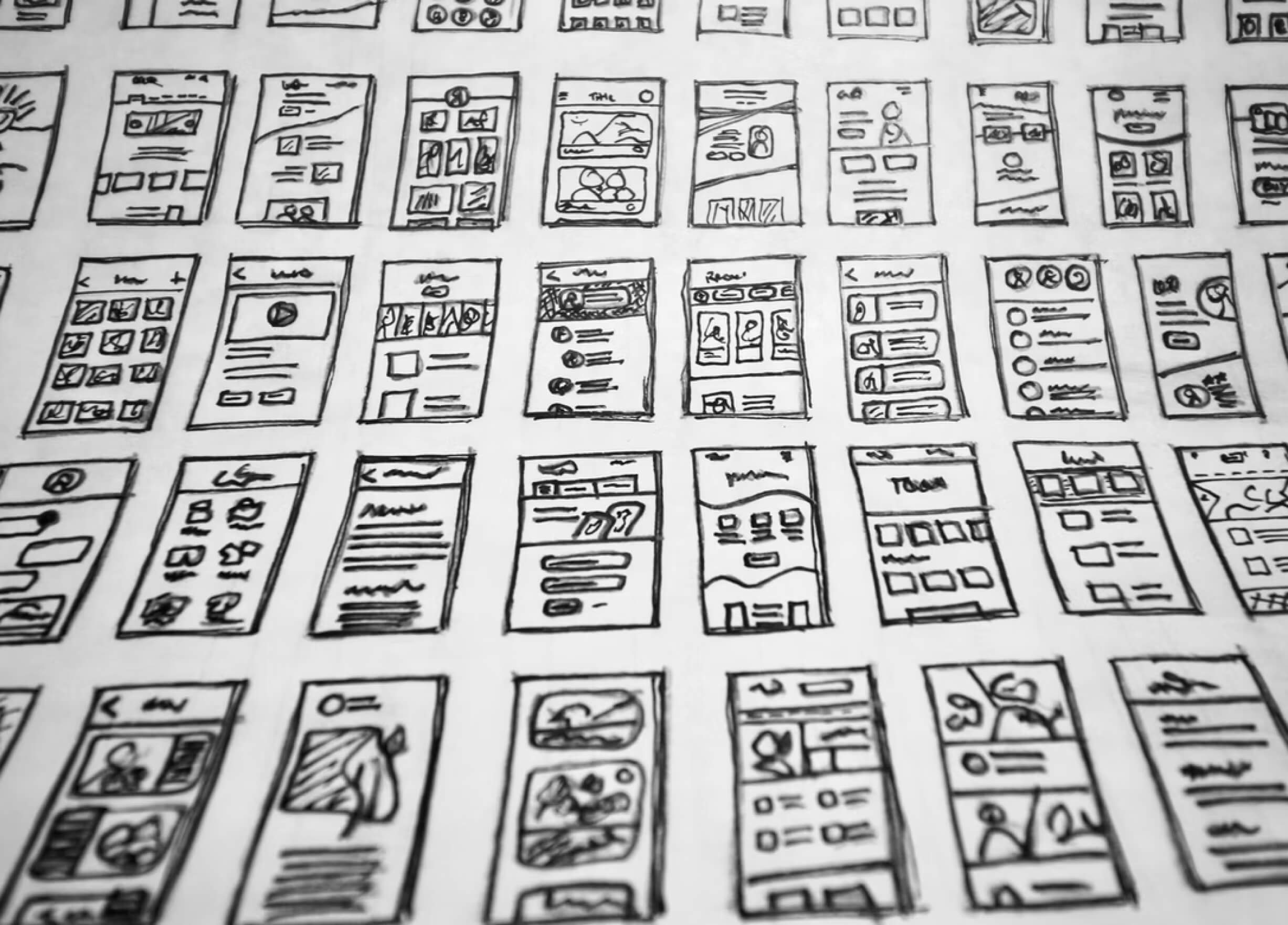 Many hand drawn wireframes on a white paper